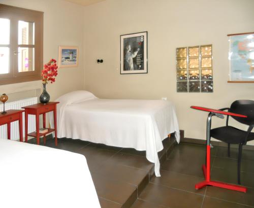 a white bed in a room with a table and a chair at Charming house with sea view in Chrousa, fenced garden in Chrousa