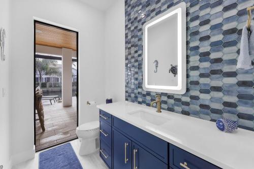 a bathroom with a sink and a mirror at Exquisite waterfront Home featuring a pool and hot tub in Marco Island
