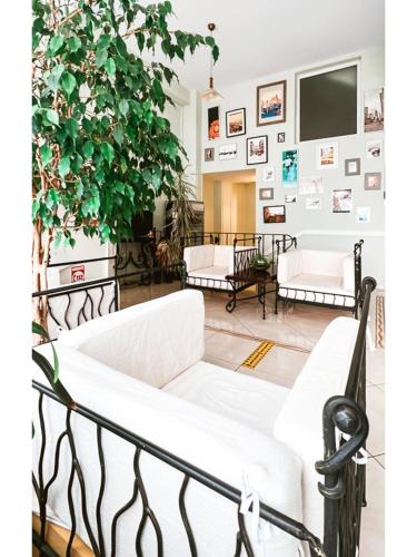 a living room with white couches and a plant at Vila Roma in Deva