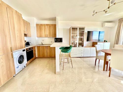 une cuisine avec lave-linge, sèche-linge et une table dans l'établissement Monte Carlo Vista - Vue Mer - Terrasse, à Beausoleil