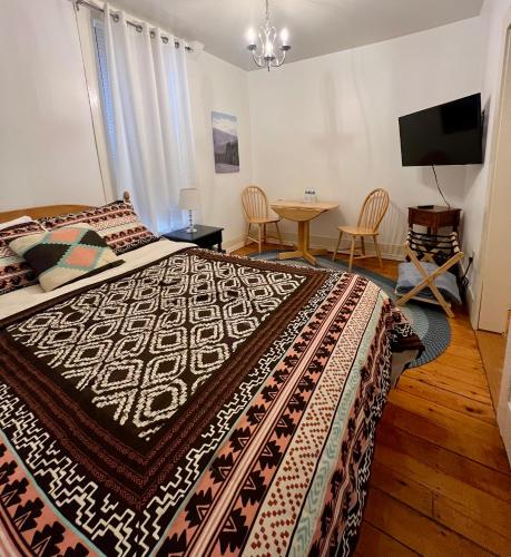 a bedroom with a large bed and a table at Allegory Inn in Twin Mountain