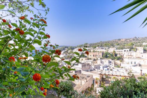 a view of a city with flowers in the foreground at Villa Blu La Cambusa in Castro di Lecce