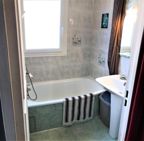 une salle de bain avec une baignoire et un lavabo dans l'établissement Les Sablettes studio et sa loggia vue mer, à La Seyne-sur-Mer