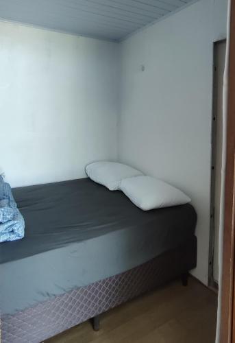 a bed with two pillows on it in a room at Picco da Ilha Hostel in Florianópolis