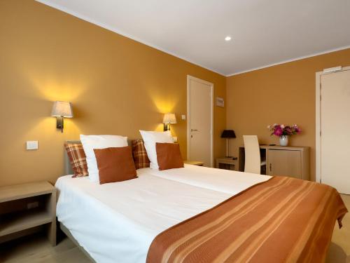 a bedroom with a large bed with white sheets at Hotel Pavillon Du Zoute in Knokke-Heist