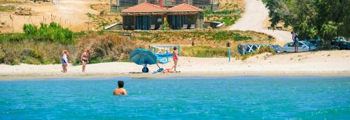 a group of people in the water at a beach at Amari Stone Apartments in Moudhros