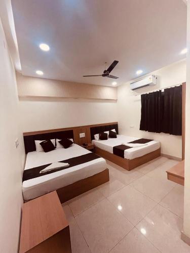 ウッジャインにあるHotel Siddhi Shreeのベッド2台と天井のある寝室