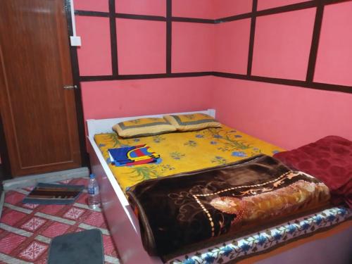 a bed in a room with a pink wall at EHI Homestay in Pedong