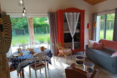 a living room with a table and a couch at Restored barn in its Landes airial in Léon
