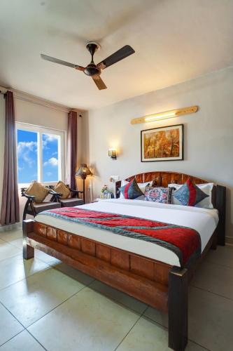 a bedroom with a large bed with a ceiling fan at Nature's Vibe Stays Mukteshwar - A 4BHK Plum Orchard Villa in Mukteswar