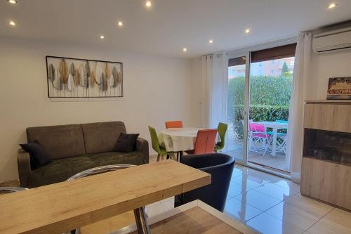 un salon avec un canapé et une table dans l'établissement Charming T2 100 meters from the beach, à Fréjus