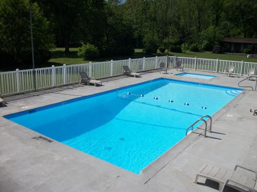 a large blue swimming pool with chairs around it at Two Rivers Lodge in Bryson City