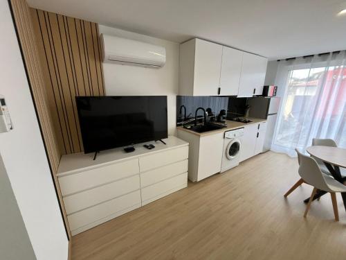 a kitchen with a flat screen tv and a table at Appartement confortable et cosy près de Braga in Pico