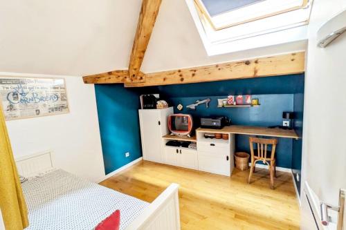 une chambre avec un mur bleu et un bureau dans l'établissement Charming family duplex in the 7th - Lyon, à Lyon