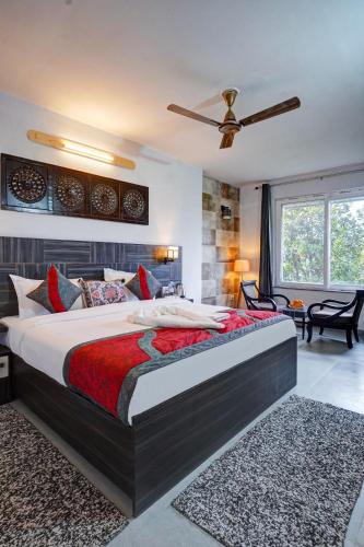 a bedroom with a large bed and a ceiling fan at Nature's Vibe Stays Mukteshwar - A 4BHK Plum Orchard Villa in Mukteswar