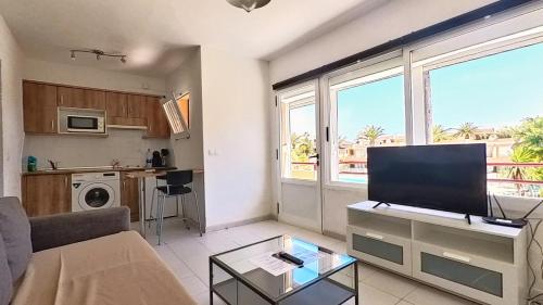 a living room with a couch and a tv at Residencial Las Dunas, Best Holiday Home Resort On The Island- VV in Corralejo