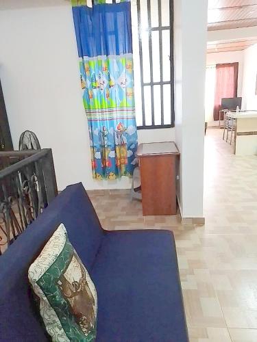 a living room with a blue couch with a pillow at CÓMODO APARTAMENTO CENTRAL EN BARRIO SEMI RURAl in Villavicencio