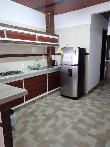 a kitchen with a stainless steel refrigerator in a room at CÓMODO APARTAMENTO CENTRAL EN BARRIO SEMI RURAl in Villavicencio