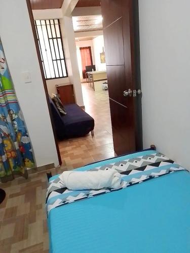 a bedroom with a bed and a living room at CÓMODO APARTAMENTO CENTRAL EN BARRIO SEMI RURAl in Villavicencio
