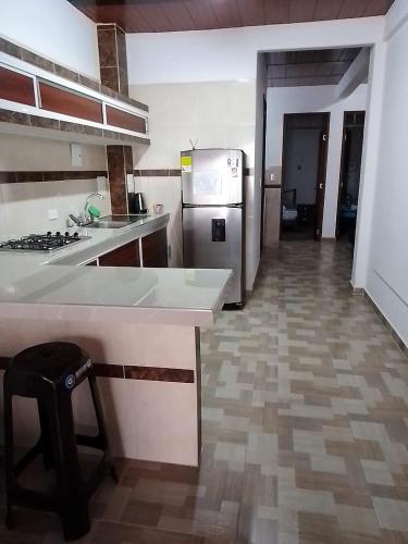 a kitchen with a counter and a stove and a refrigerator at CÓMODO APARTAMENTO CENTRAL EN BARRIO SEMI RURAl in Villavicencio