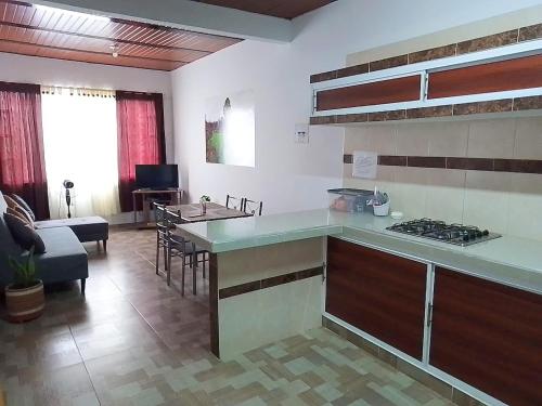 a kitchen with a counter top and a living room at CÓMODO APARTAMENTO CENTRAL EN BARRIO SEMI RURAl in Villavicencio
