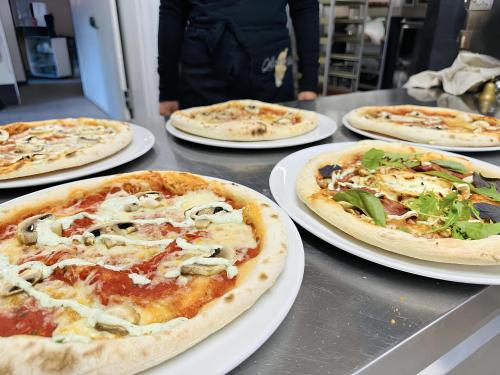 a group of pizzas on plates on a table at STF Hostel Lärbro/Grannen in Lärbro