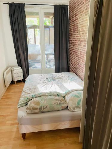 un petit lit dans une chambre avec une fenêtre dans l'établissement Départ tardif appartement T2 avec 1 chambre centre Orléans, à Orléans