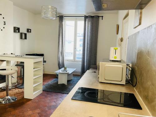 une cuisine avec un comptoir avec un micro-ondes dessus dans l'établissement Départ tardif appartement T2 avec 1 chambre centre Orléans, à Orléans