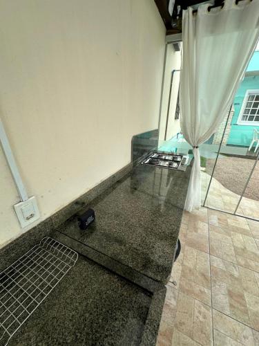 a room with a glass table and a curtain at 01 - Casa Praia da Pinheira in Palhoça