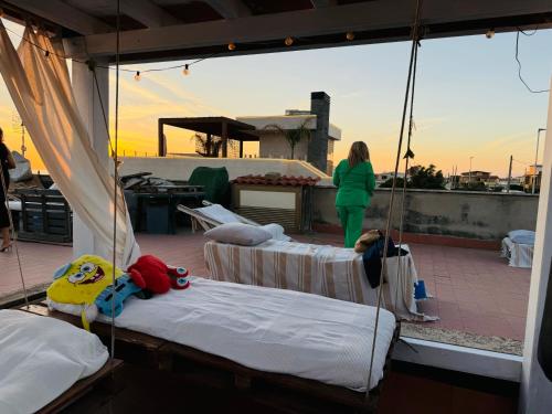 a woman standing on top of a balcony with two beds at Stanza relax con uscita sulla spiaggia in Focene
