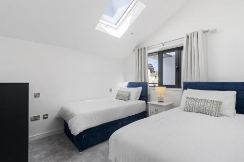 a bedroom with two beds and a window at Teign View, Grand Banks in Teignmouth