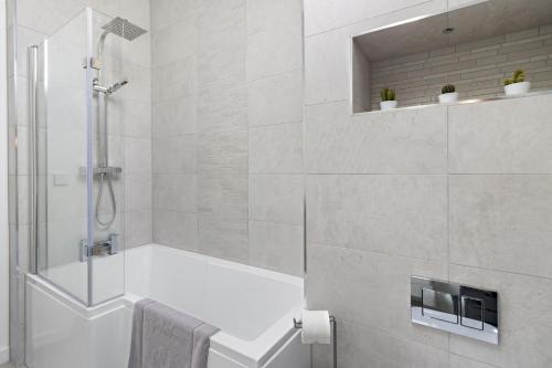 a bathroom with a shower and a bath tub at Teign View, Grand Banks in Teignmouth