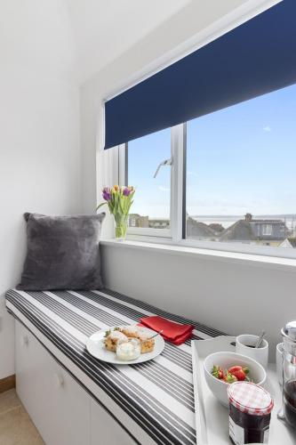 a table with a plate of food on a window sill at Seaway Garden, Beachside Maisonette with Parking in Paignton