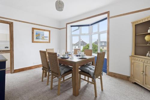 a dining room with a table and chairs and a window at Seaway Garden, Beachside Maisonette with Parking in Paignton