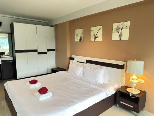 a bedroom with a large white bed with two red pillows at Aonang Mountain View A2 in Ao Nang Beach