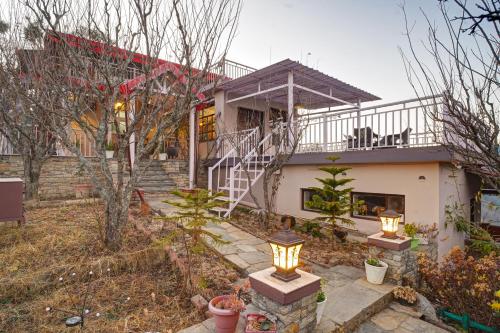a house with a staircase in front of it at Nature's Vibe Stays Mukteshwar - A 4BHK Plum Orchard Villa in Mukteswar