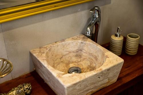 a stone sink in a bathroom with a faucet at Villa Lapax by Ericeira Property in Ericeira