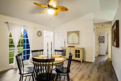 Un comedor con mesa y sillas y un ventilador de techo. en Families and large groups, with TVs in every room, en Palm Bay