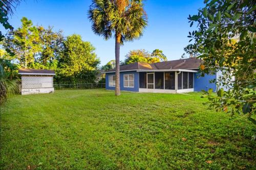 una casa azul con una palmera en el patio en Families and large groups, with TVs in every room, en Palm Bay
