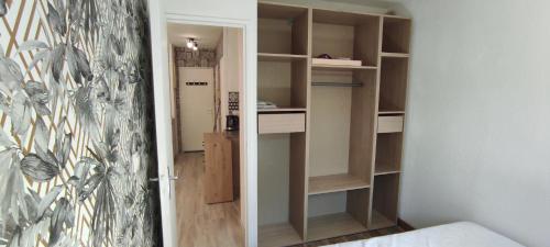 Cette chambre dispose d'un placard avec des étagères en bois. dans l'établissement Appartement T2 avec jardin, à Saint-Mandrier-sur-Mer
