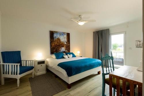 a bedroom with a bed and a chair and a window at Villa Lapax by Ericeira Property in Ericeira