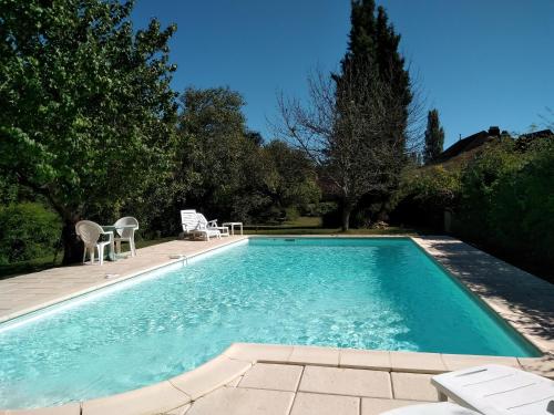 une piscine avec deux chaises et une table dans l'établissement Villa EsquirHall, chambres d'hôtes, à Journiac