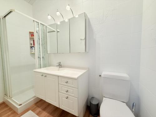 une salle de bain blanche avec des toilettes et un lavabo dans l'établissement Villa Joséphine Plage de Boyard, à Saint-Georges-dʼOléron