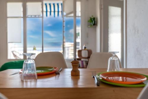 une table en bois avec des assiettes et des bouteilles en verre dessus dans l'établissement Il Sole e Mare, à Nice