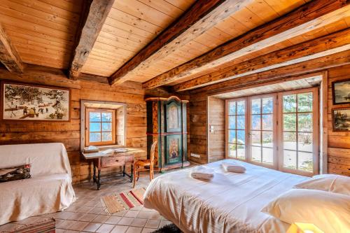 Un dormitorio con dos camas en una habitación con paredes de madera. en Slow Chalet de l'Ourse - Charming old chalet stunning view sauna pets ok, en Serraval