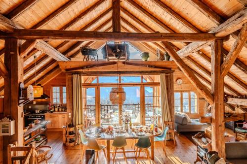 Un comedor con mesa y sillas en un edificio. en Slow Chalet de l'Ourse - Charming old chalet stunning view sauna pets ok, en Serraval