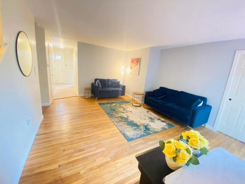 a living room with a blue couch and yellow flowers at 1 bedroom terrace view with shared bathroom #3 in Laurel