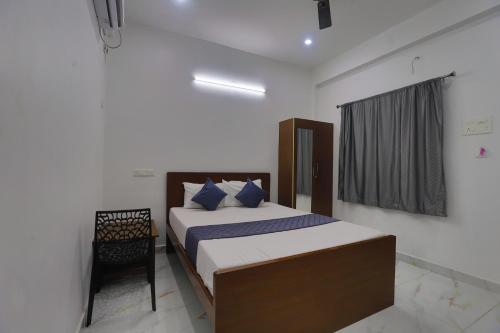 a bedroom with a bed and a chair in it at RN stays near by chennai airport in Chennai