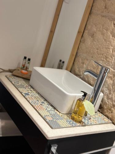 a white sink on a counter with a bottle of soap at Casa da Villa in Vila Nova de Foz Coa