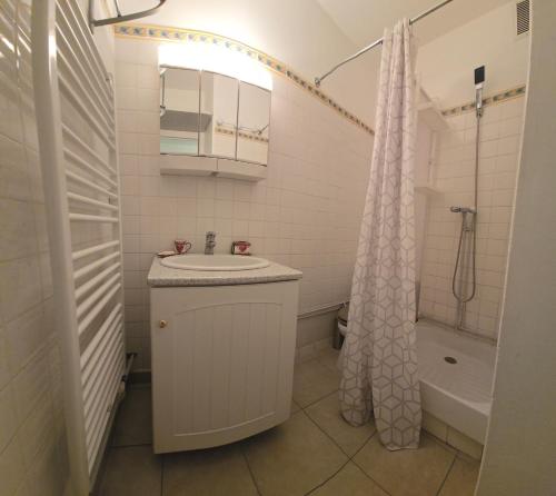 une salle de bain blanche avec un lavabo et une douche dans l'établissement studio au Pieds des pistes station Superdévoluy, à Saint-Étienne-en-Dévoluy